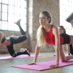Jeunes femmes faisant du fitness sur des tapis dans une salle de sport