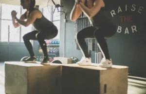 Deux sportives en train de faire des exercices d'étirement dans une salle de sport pour faire du fitness